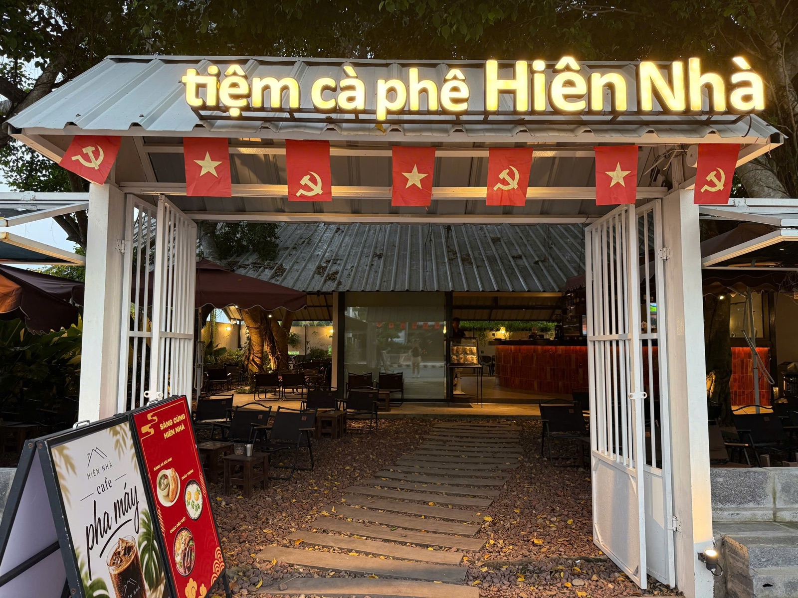Cổng và biển hiệu tiệm cà phê Hiên Nhà cùng khoảng sân ngoài trời